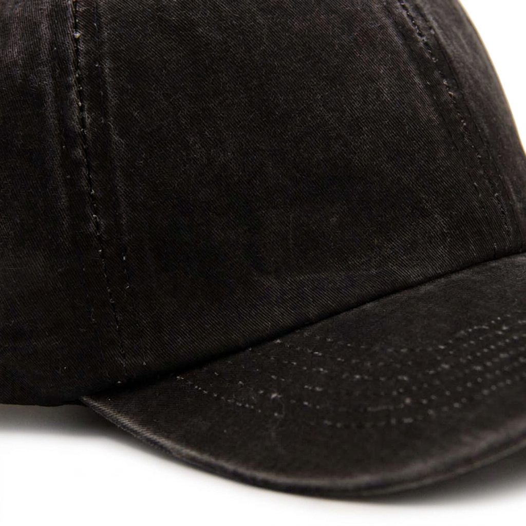 Detalle de la visera del jockey prelavado negro sobre fondo blanco