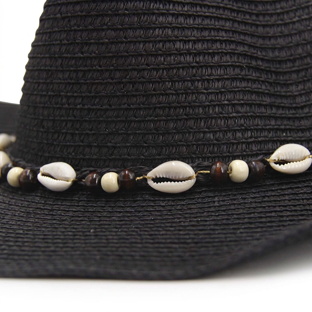 Detalle de conchas y cuentas del sombrero negro con fondo blanco