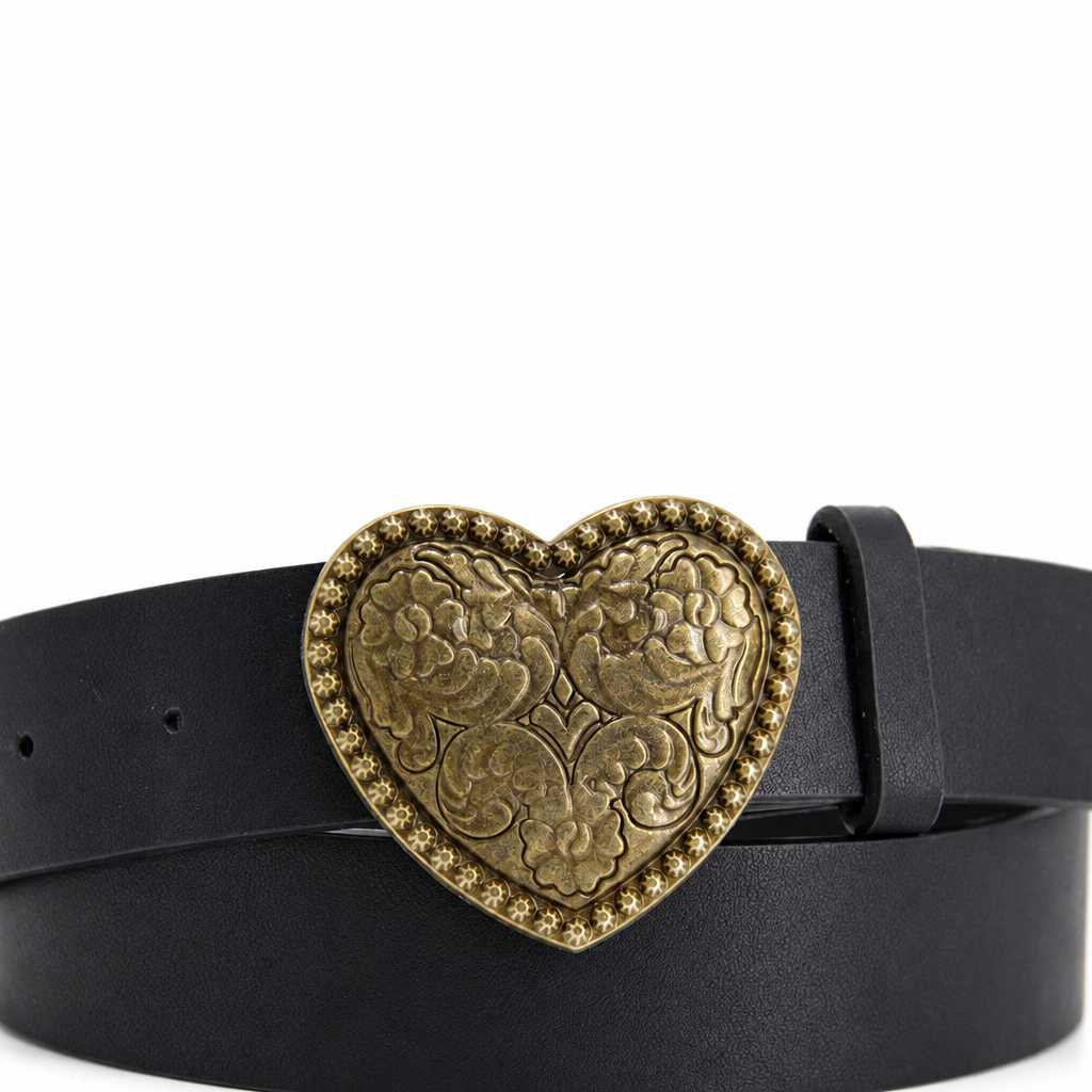 Detalle frontal de hebilla de corazón dorado del cinturón negro sobre fondo blanco